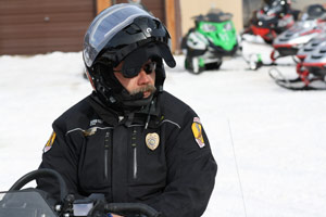 Police patrolling trails by snowmobile