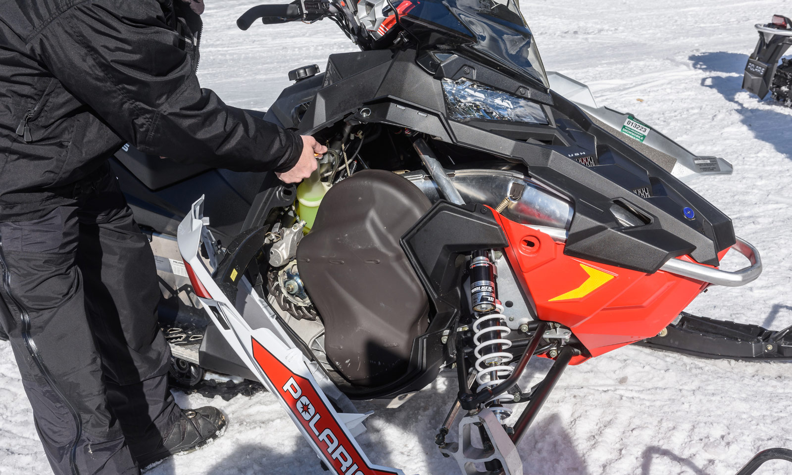 Snowmobiler checking fluid level