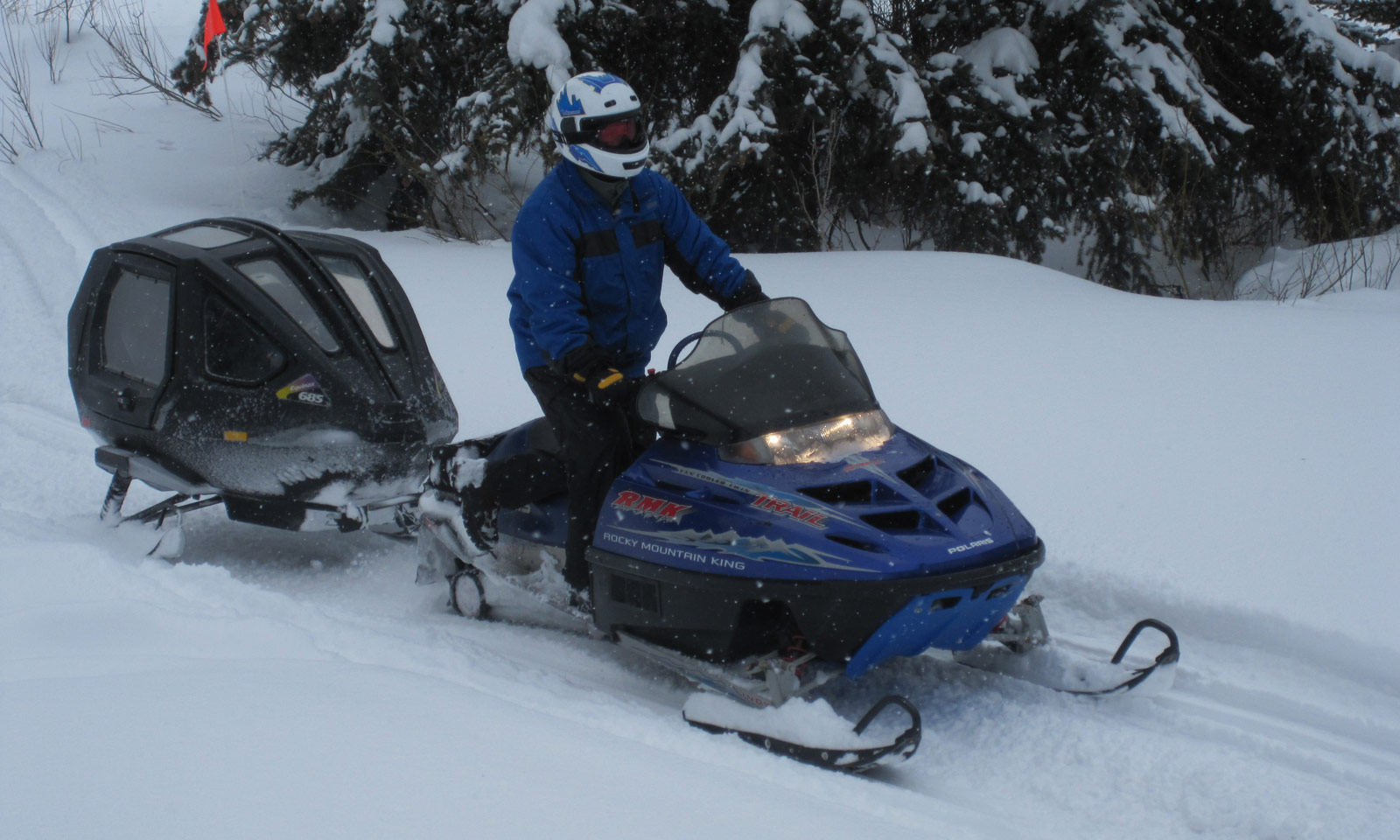 Snowmobiler towing a cutter