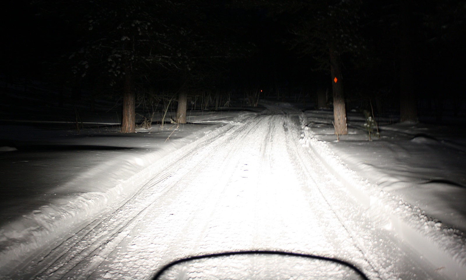 Snowmobile with lights showing at night